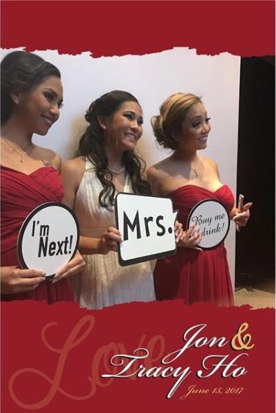 Three women with sign props posing in front of a white backdrop