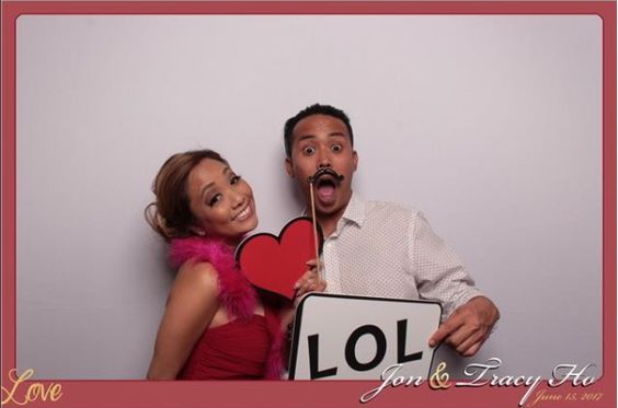 Couple posing with props and white backdrop