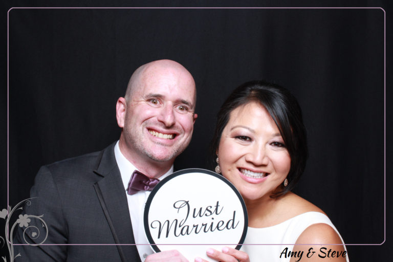couple with just married prop in front of black backdrop
