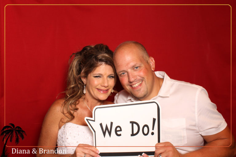 couple posing with red backdrop and we do prop