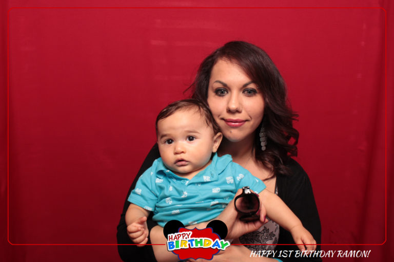Woman with baby posing in front of red backdrop