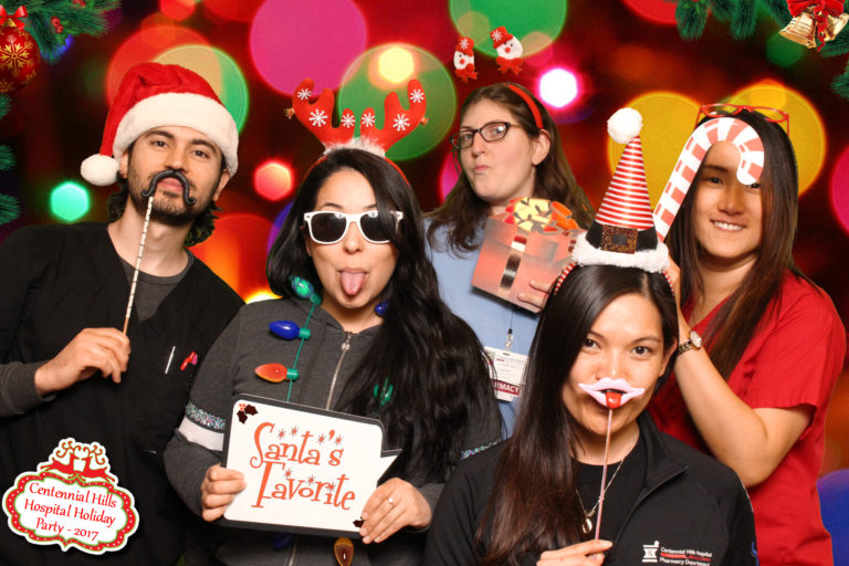 Group with Christmas props and sunglasses in front of backdrop