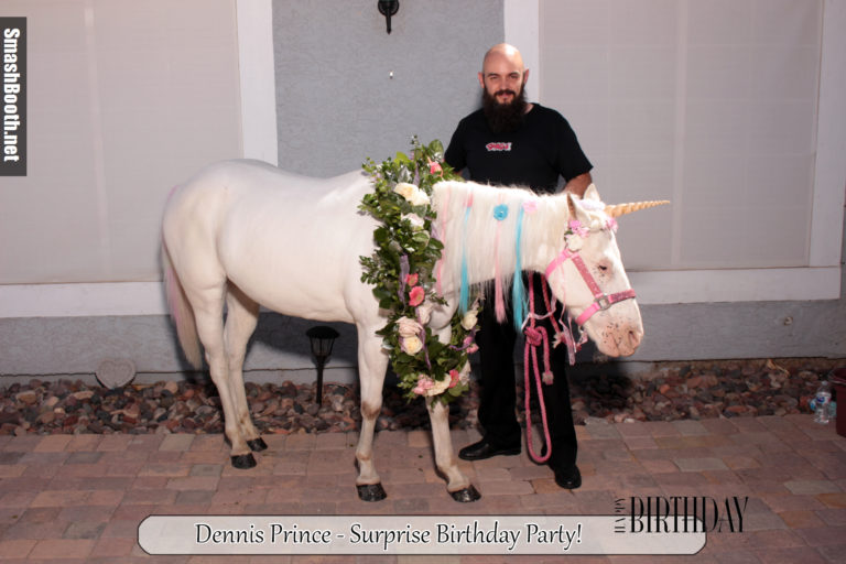 Man with beard posing with a horse dressed to look like a unicorn
