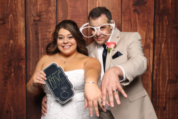Couple with props and glasses posing with brown backdrop