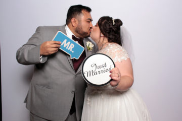 Couple with props posing in front of white backdrop