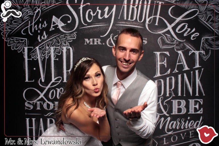 couple posing with chalkboard backdrop