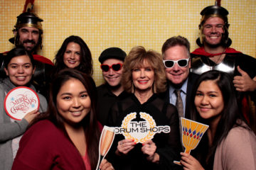 Group with props posing in front of a gold shimmer backdrop
