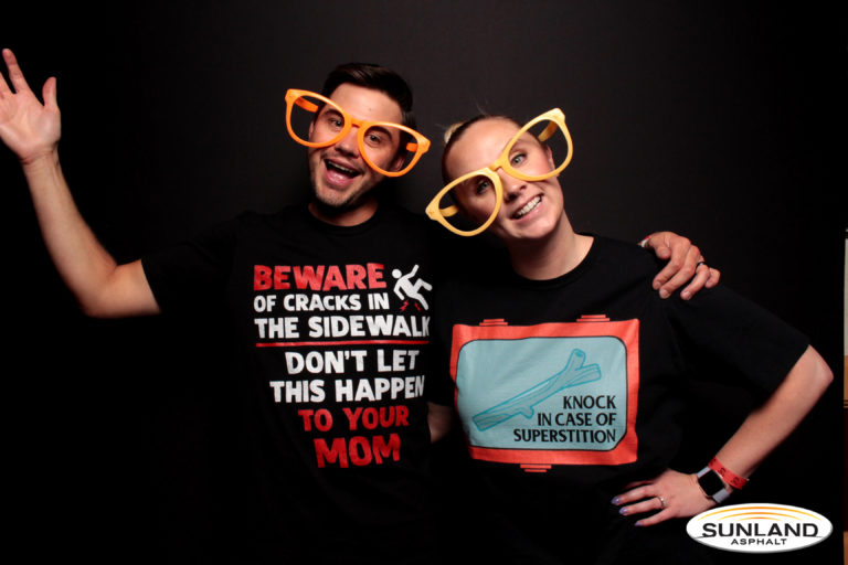 Couple posing with black backdrop and sunglasses props