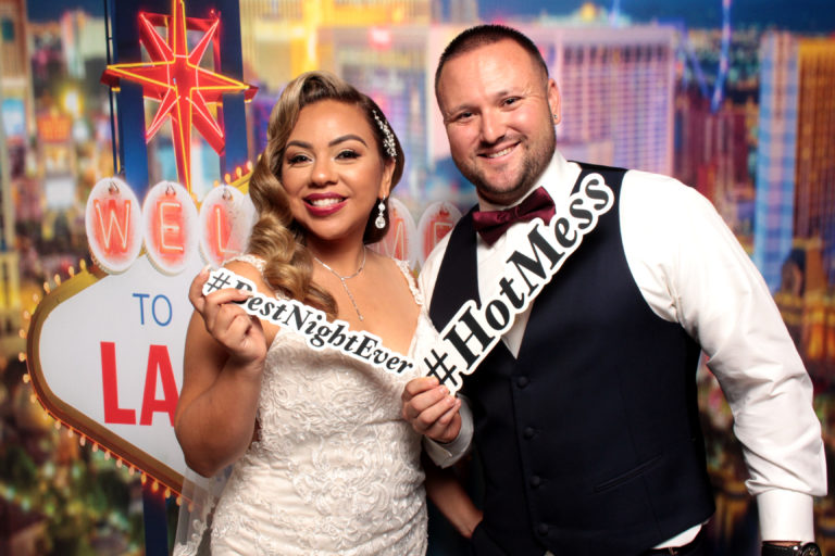 Couple posing with Vegas Strip backdrop and props