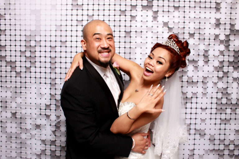 Couple posing with silver shimmer backdrop