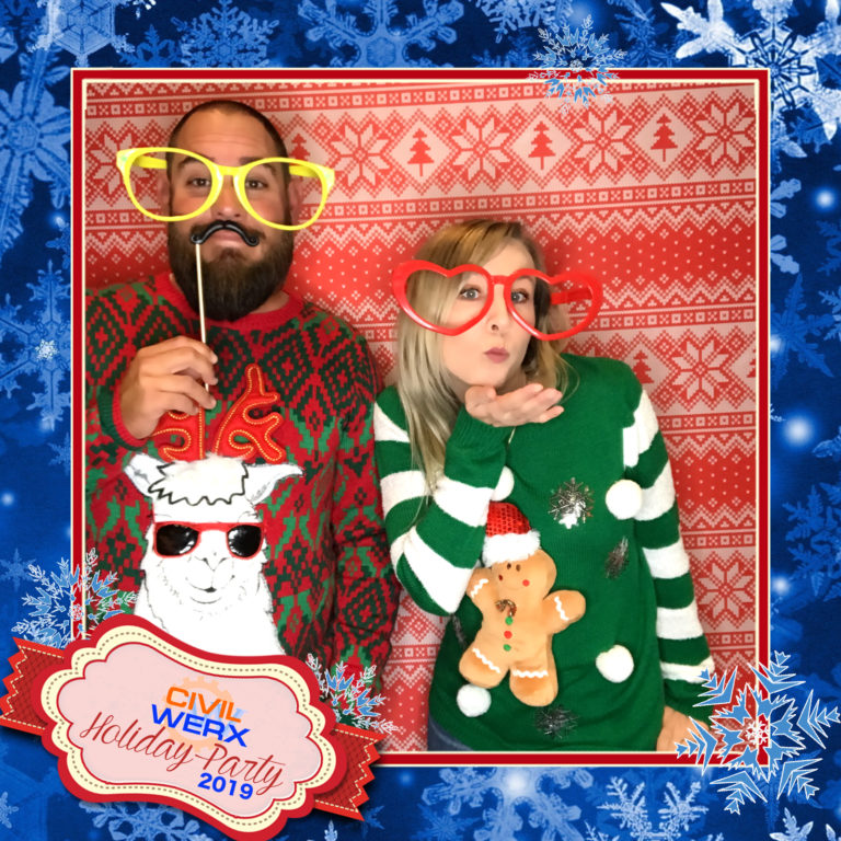 couple posing with ugly sweater backdrop and props