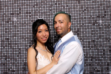 couple posing with silver shimmer backdrop