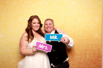 couple posing with gold shimmer backdrop