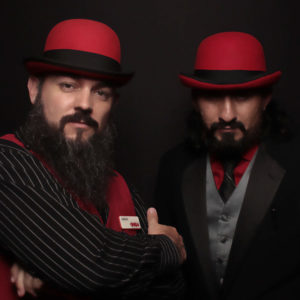 Smashbooth employees posing with black backdrop and red hats Photo Booth Rentals in Las Vegas Smash Booth