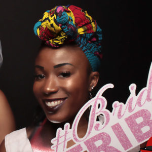 woman posing with black backdrop and sign prop Photo Booth Rentals in Las Vegas Smash Booth