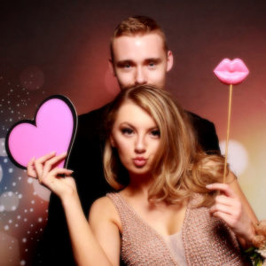 couple posing with dark bokeh backdrop with props Photo Booth Rentals in Las Vegas Smash Booth
