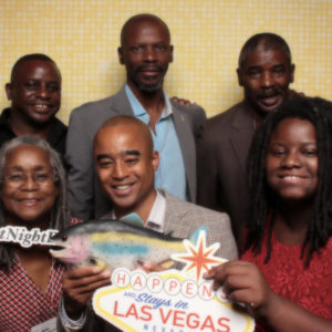 group pose with gold shimmer backdrop and Vegas sign Photo Booth Rentals in Las Vegas Smash Booth