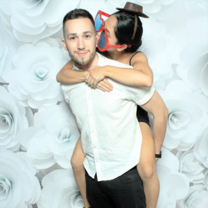couple posing with flower wall backdrop Photo Booth Rentals in Las Vegas Smash Booth