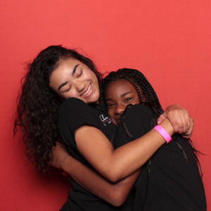 women hugging in front of red backdrop Photo Booth Rentals in Las Vegas Smash Booth