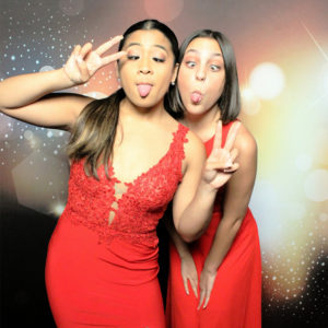 Two women posing with dark bokeh backdrop with red dresses Photo Booth Rentals in Las Vegas Smash Booth