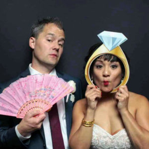 couple posing with black backdrop and props Photo Booth Rentals in Las Vegas Smash Booth