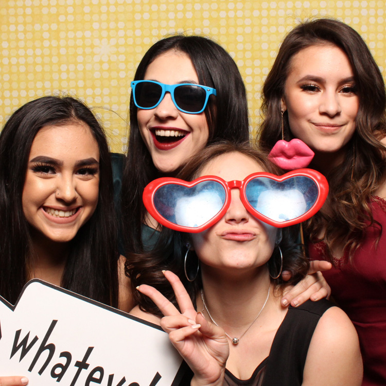 women posing with gold shimmer backdrop and props