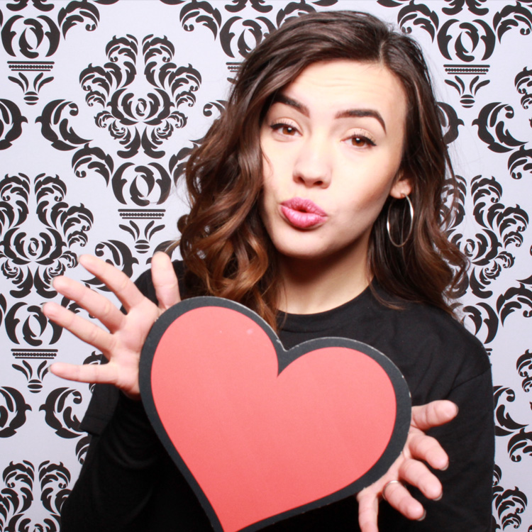 woman posing with damask backdrop and heart prop