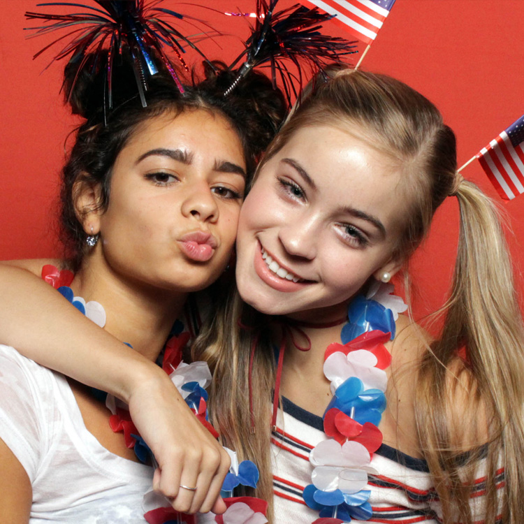 two women posing with red backdrop