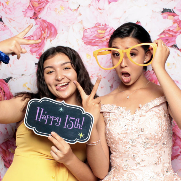 women posing with pink backdrop and props