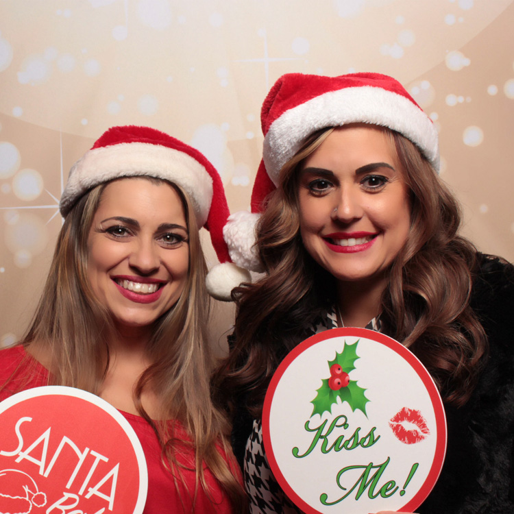 two women with Christmas props posing with light bokeh backdrop