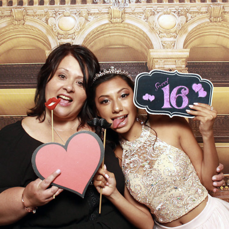 two women posing with backdrop and props