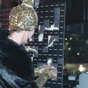 woman in gold hat placing sticker on board Photo Booth Rentals in Las Vegas Smash Booth
