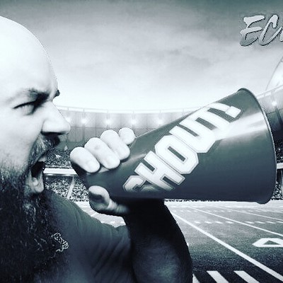 Bearded-man-posing-with-a-megaphone-in-a-sports-stadium-scene-using-AI-powered-background-removal-by-Smash-Booth’s-premium-photo-booth-experience