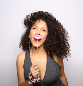 woman-smiling-while-blowing-bubbles-at-smash-booth-event