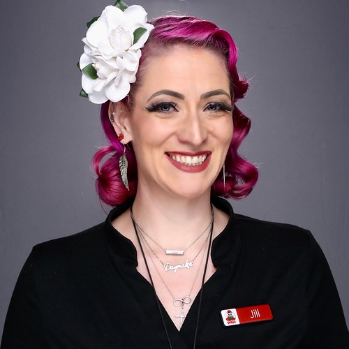 woman-with-pink-hair-and-flower-accessory-smiling