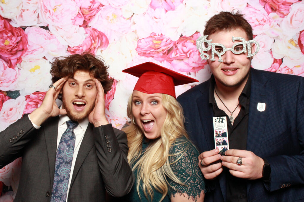graduation-photo-booth-with-friends-wearing-caps-and-fun-party-accessories