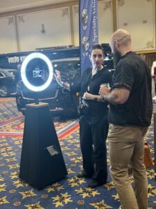 two-men-standing-next-to-photo-booth-with-ring-light