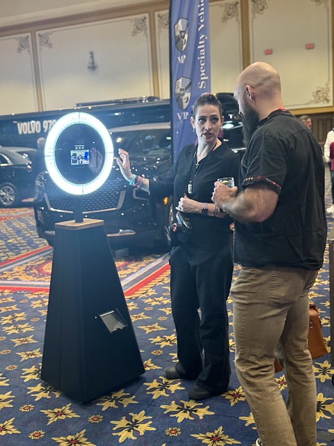 two-men-standing-next-to-photo-booth-with-ring-light