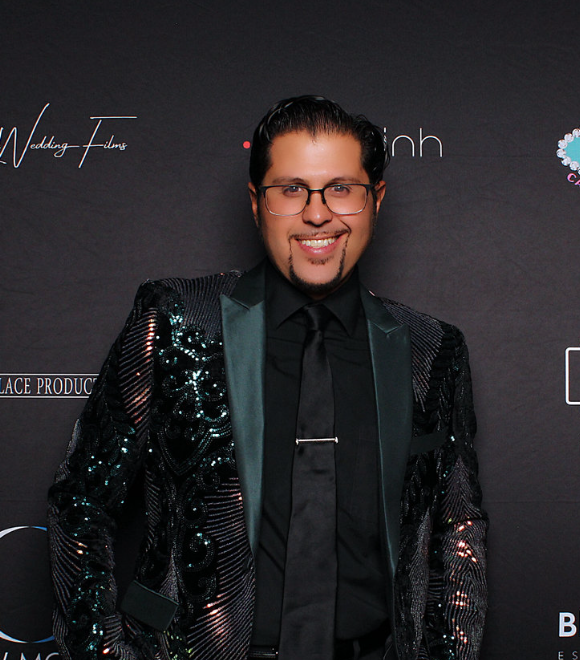 man-in-black-sequin-jacket-smiling-on-smash-booth-red-carpet