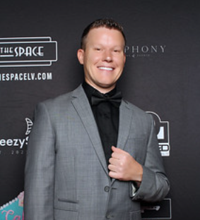 man-in-gray-coat-smiling-in-fron-of-smash-booth-photo-booth-camera