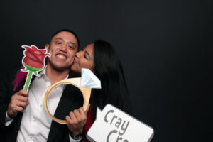 couple-holding-crazy-prop-signs-in-photo-booth