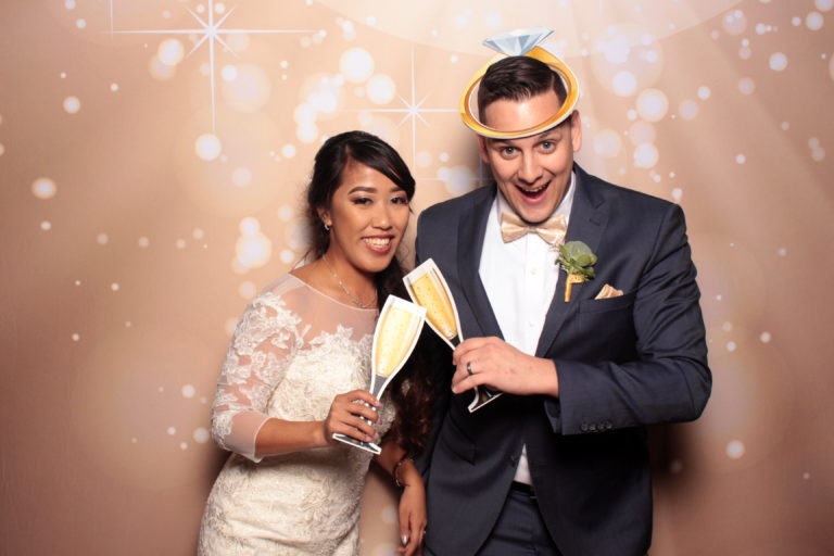 wedding-photo-booth-with-newlyweds-celebrating-with-props-and-backdrop