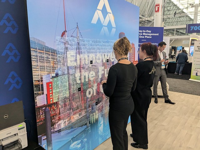 woman-viewing-exhibit-booth-display-at-trade-show-with-smash-booth-photo-area