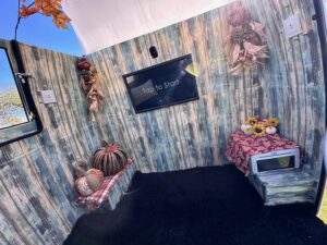 rustic-photo-booth-with-autumn-themed-backdrop-and-tv-screen
