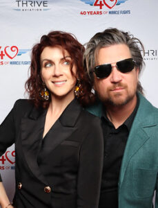 couple-posing-on-red-carpet-in-front-of-event-banner-at-smash-booth