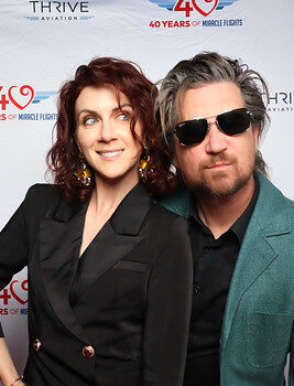couple-posing-on-red-carpet-in-front-of-event-banner-at-smash-booth