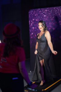 woman-in-red-hat-facing-two-women-in-black-dresses-at-event