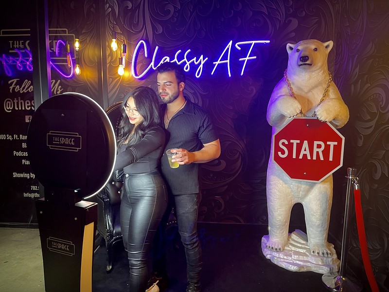 Woman-in-metallic-catsuit-posing-at-Classy-AF-photo-booth-activation-with-neon-signs