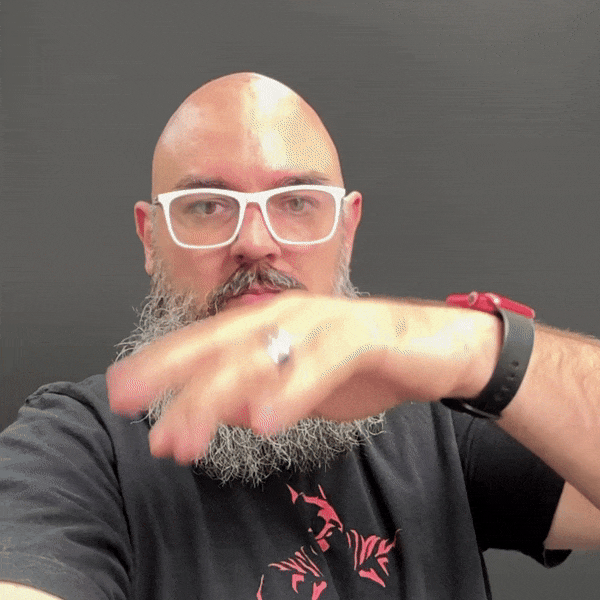 Bald-man-posing-with-hand-slow-motion-in-front-of-black-backdrop-at-photo-booth