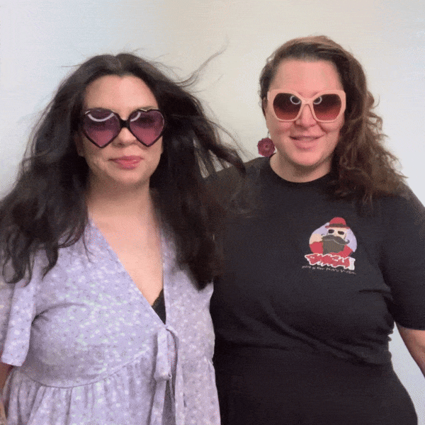 Two-women-in-sunglasses-posing-together-at-outdoor-event-photo-booth